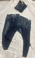 All five folded and opened jeans to show front and back styling