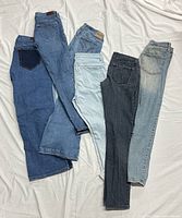 All six pairs of jeans laid out showing full length and color variations