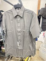 Front view of one gray button-down shirt showing collar, buttons, tag