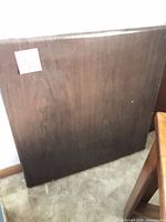 Front view of folded table showing dark brown laminate top