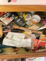 Drawer view showing multiple hand tools, packaged hardware and tape