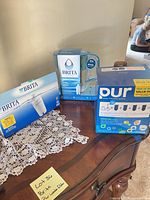 Brita filter pack, Brita pitcher box, PUR faucet filter pack on table