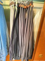Row of charcoal and gray dress trousers on hangers