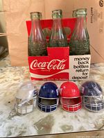 Bottles in carrier with helmets displayed