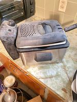 Exterior view showing stainless steel body, black lid and control panel