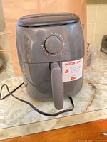 Front view of gray Dash air fryer showing control dial and power cord