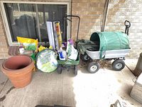 All items grouped on patio: wagon, spreader, planter, bags, accessories