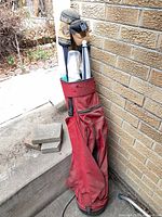 Full view of red golf bag with clubs and accessories