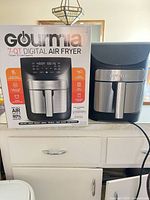 Retail box next to air fryer showing model and specs