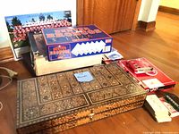Lot overview showing Broncos Trivia game, Labyrinth game box edge, poster, UNO decks, and closed inlaid wood board