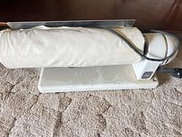 Side view of Kelvinator roller iron showing fabric-covered roller and base