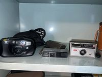 All three cameras with two cases in cabinet shelf