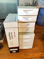 Plastic six-drawer tower beside boxed organizer
