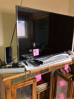 LG 43-inch TV on cabinet with remote and antenna visible