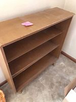 Front angled view of full bookshelf showing shelves and turned feet