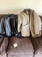Both jackets laid flat on sofa