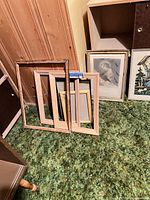 Group of wood frames and prints on floor showing quantity and variety