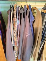 Assorted jackets, shirts and sweaters hanging in closet