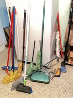 Group of cleaning tools in front of fridge