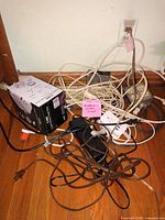 Pile of extension cords, power strips, adapters on floor