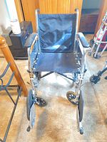 Front view, seat, armrests, casters, footrest mounts visible