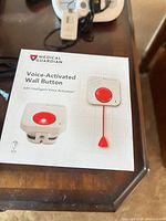 Front of box showing Medical Guardian voice-activated wall button product image and branding