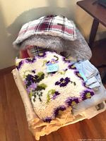Overall lot showing throws, hooked rug, sheets in laundry basket