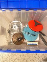 Top view of tote showing enamel saucepan, glass baking dishes with lids, amber lid, boxed double-boiler insert