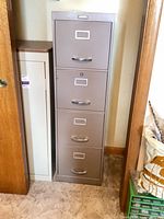 Full view of filing cabinet front showing four drawers and overall condition