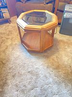 Full view of octagonal side table showing glass top and shelf