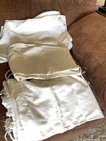 Stack of off-white drawstring laundry bags and cloths