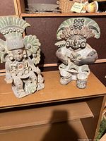 Both terracotta figurines side by side on shelf
