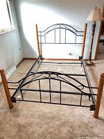 assembled queen bed frame showing headboard, footboard, side rails and wood posts