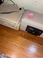 Closed Sentry safe beside Canon copier on floor