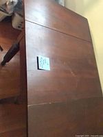 Top view of dark brown drop-leaf table showing surface scratches and note for scale