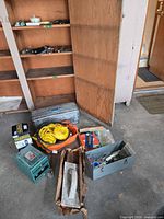 Overview of cabinet, toolboxes, extension cord, soft bag, green electric device