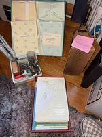 Boxed greeting card sets, glass with pencils, metal tray, stack of greeting cards