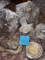 All items grouped, wrapped in plastic showing kettles, cups, butter dish and plates