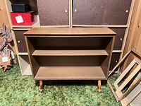 Front view showing two shelves and turned legs