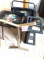 Group showing two floral trays, black stands, gold stand, wood tray table