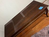 Top view of rectangular wood coffee table showing dust and reflective surface