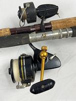 Penn 704Z reel with gold handle, Garcia Mitchell 300C reel, portions of both fishing rods including cork handles and reel seats