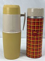 Both Thermos flasks standing side by side, full view of exterior designs