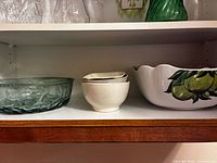 Shelf view showing glass bowl, small bowls, and fruit-decorated bowl