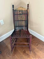 Full view of chair front showing slatted seat and back, red paint wear