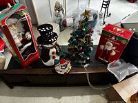 Wide shot showing both boxed Santas, snowman and tabletop tree