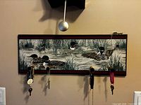 Front view of duck motif plaque showing four pegs and printed scene