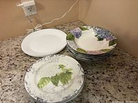 Stack of three white plates, four hydrangea salad plates, four hydrangea soup bowls