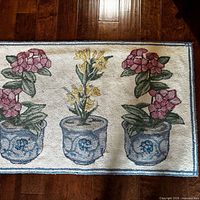 Full view of rectangular rug with floral pot motif