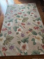 Full view of rectangular floral rug on wooden floor